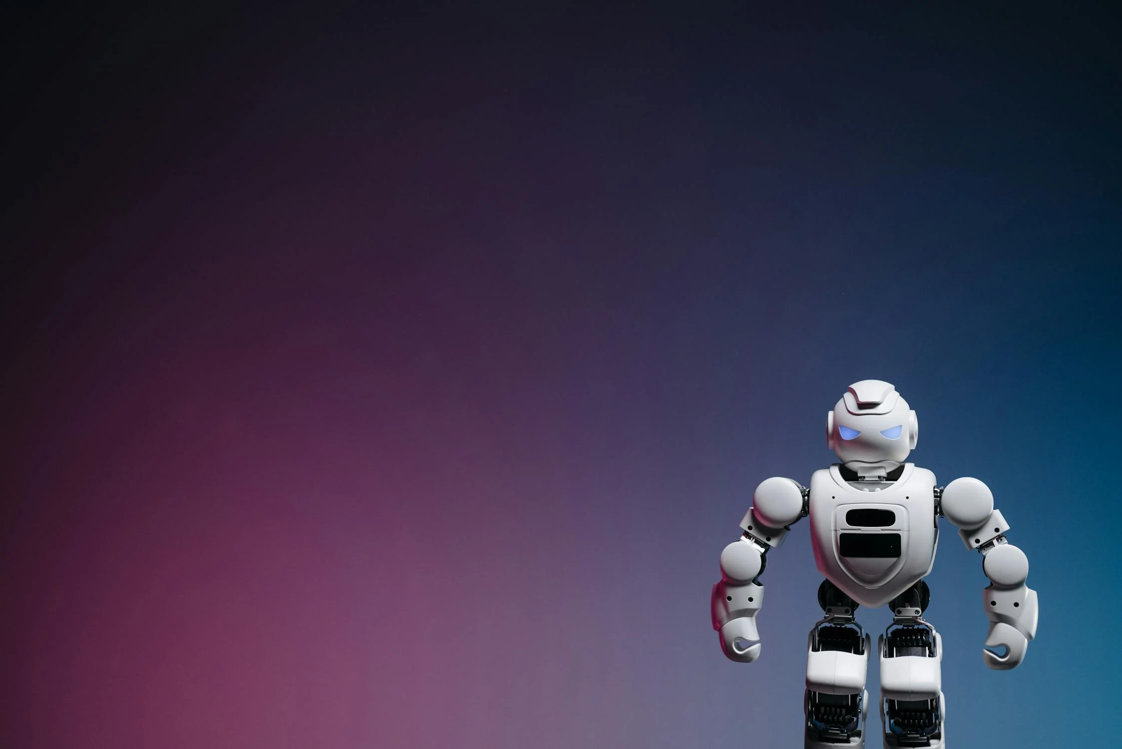 A white humanoid robot standing against a purple and blue background
