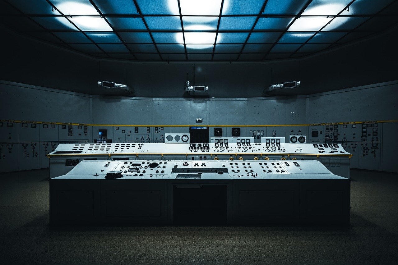 Control room consoles used to monitor automated systems, illustrating human oversight of AI agents